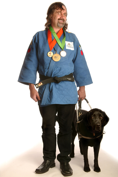 Anthony Clarke standing with his guide dog